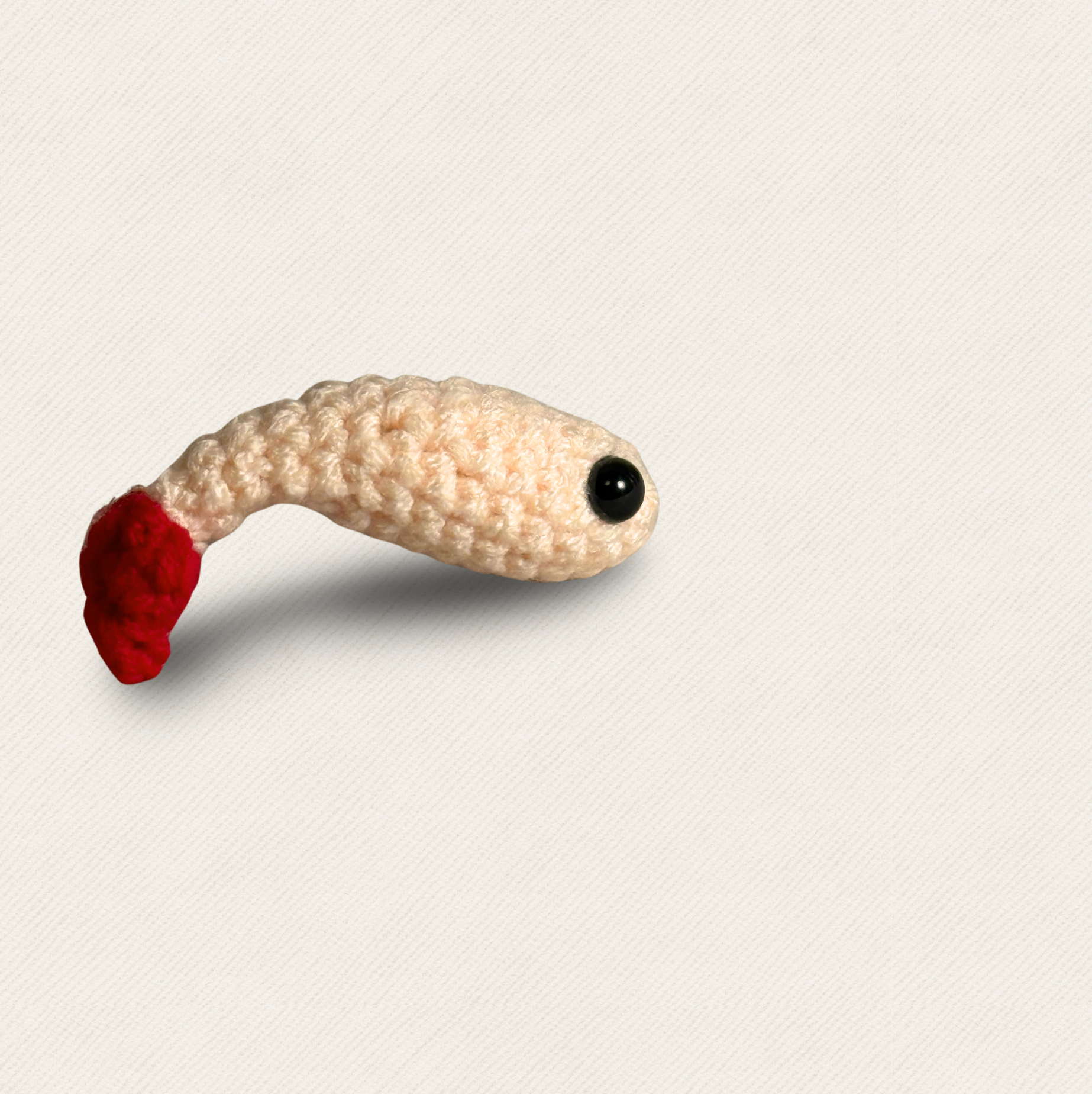Shelly the Shrimp Chunkle & Puff cat toy on neutral background, cream and red woven shrimp shape with curved body and glossy eye, textured design for batting and carrying, botanical infused independent play cat toy