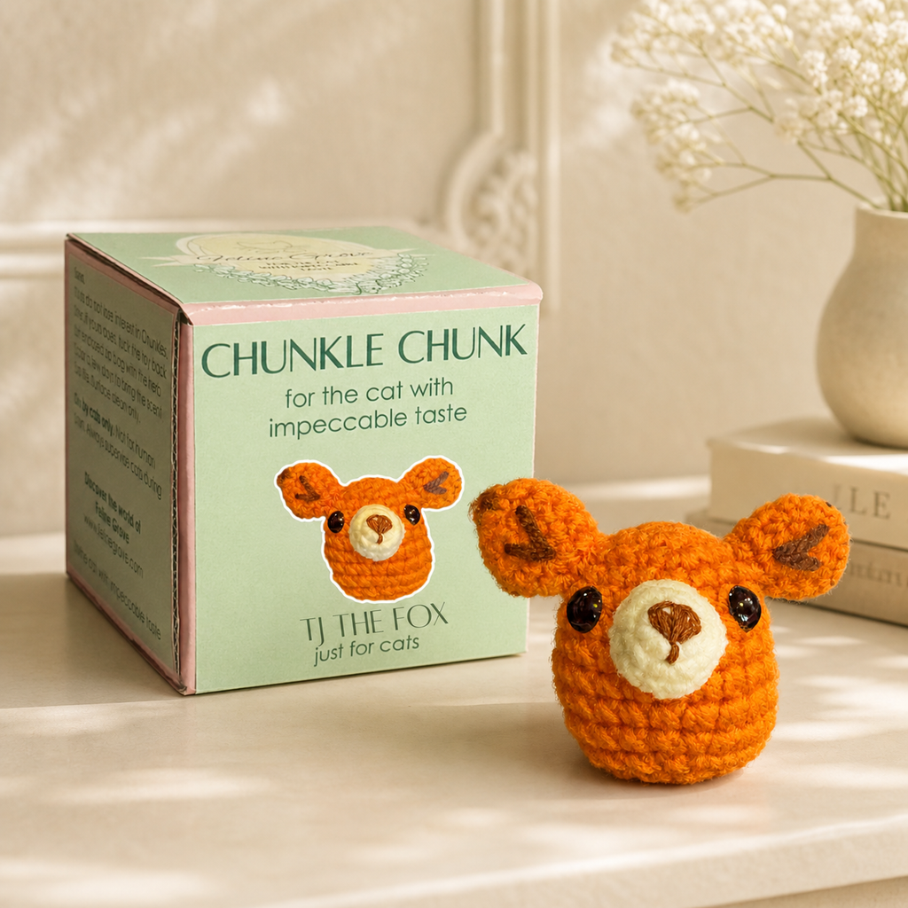 Fox shaped cat toy on tabletop with packaging in brightly lit room with books and babys breath in the background.