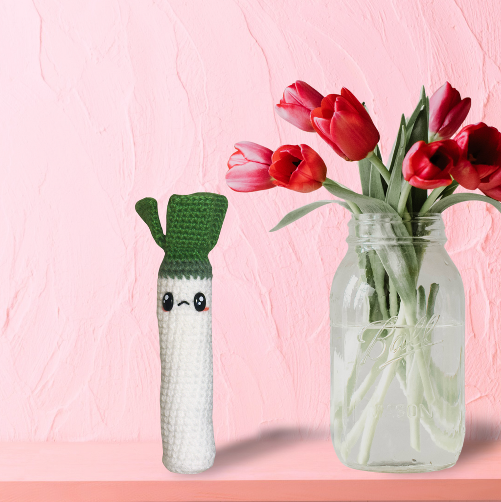 woven leek shaped cat toy beside tulips in glass jar decorative lifestyle scene featuring botanical cat toy infused with silvervine valerian gall fruit and tatarian honeysuckle