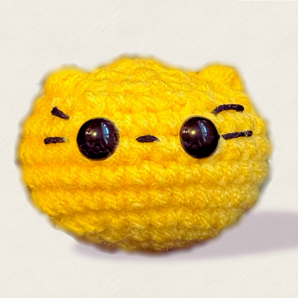 Round yellow weighted Chunkle Chunk cat toy by Chunkle & Puff on white background.