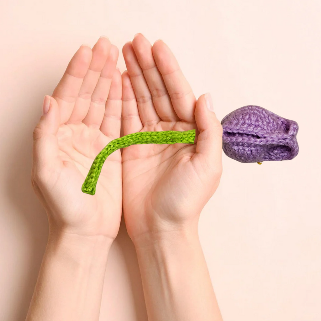 Hands holding Roselle the Tulip Chunkle & Puff cat toy showing size, woven purple flower with soft textured stem, luxury cat toy for batting carrying and bunny kicking, independent play cat toy