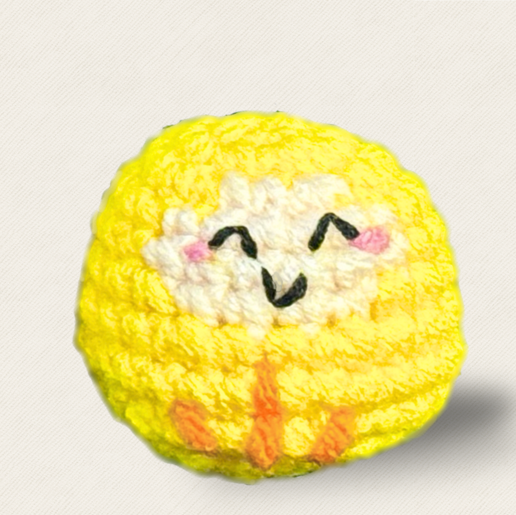 Japanese Cat Toy Daruma Doll In Yellow. Yellow daruma doll cat toy named Tamago on a white background, showing its rounded shape, smiling embroidered face, plush texture, and orange stitched details.