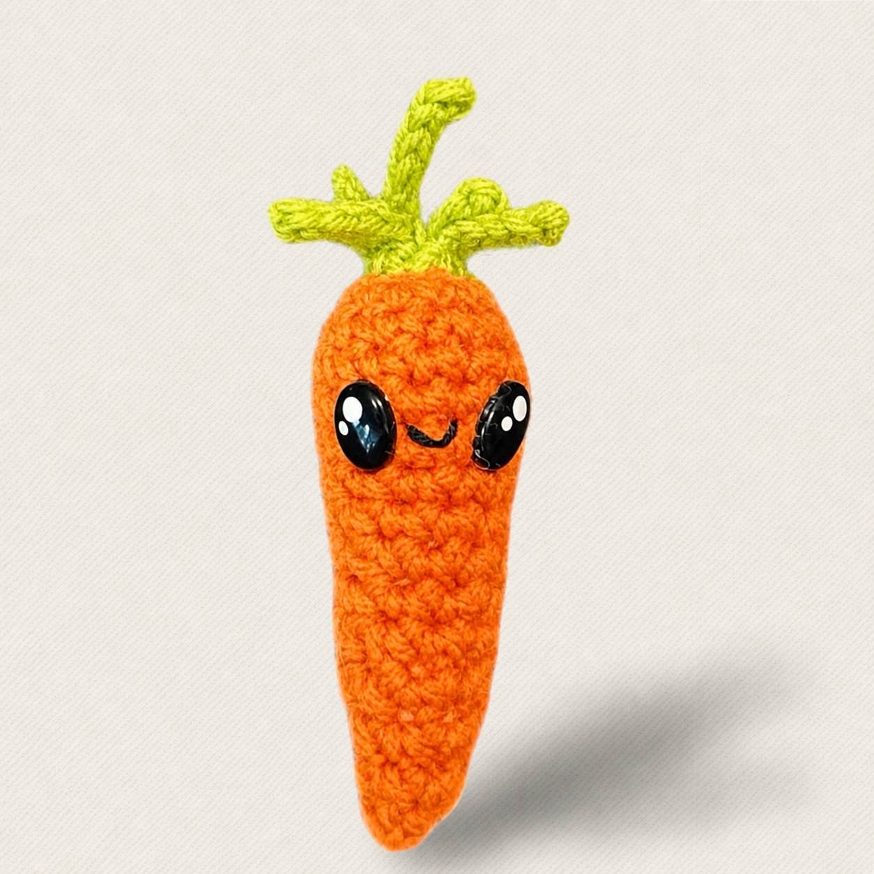 Close-up of woven carrot cat toy with glossy eyes and leafy green top, soft textured surface and compact lightweight form designed for batting and tossing, artisan Chunkle & Puff toy infused with Miracle Nip