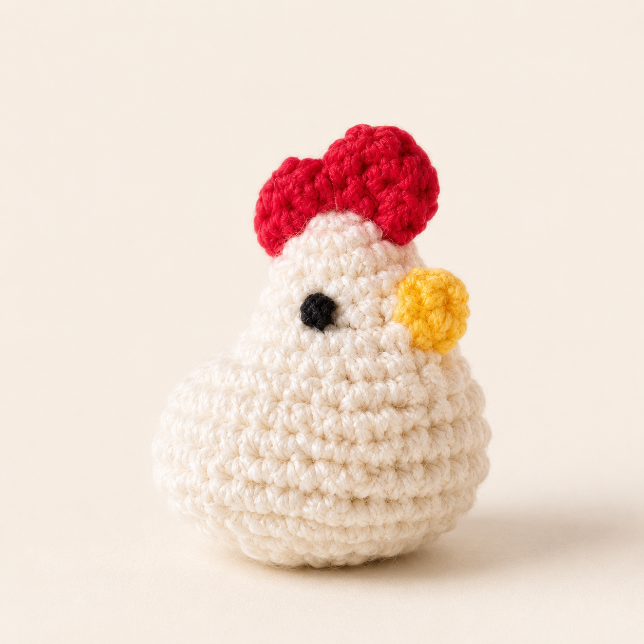 Cat Toy Hen Hero Image. Close-up of Cabbage the Hen, a small white woven hen-shaped Chunkle with a rounded body, soft textured surface, bright red comb, yellow beak, and single black eye.