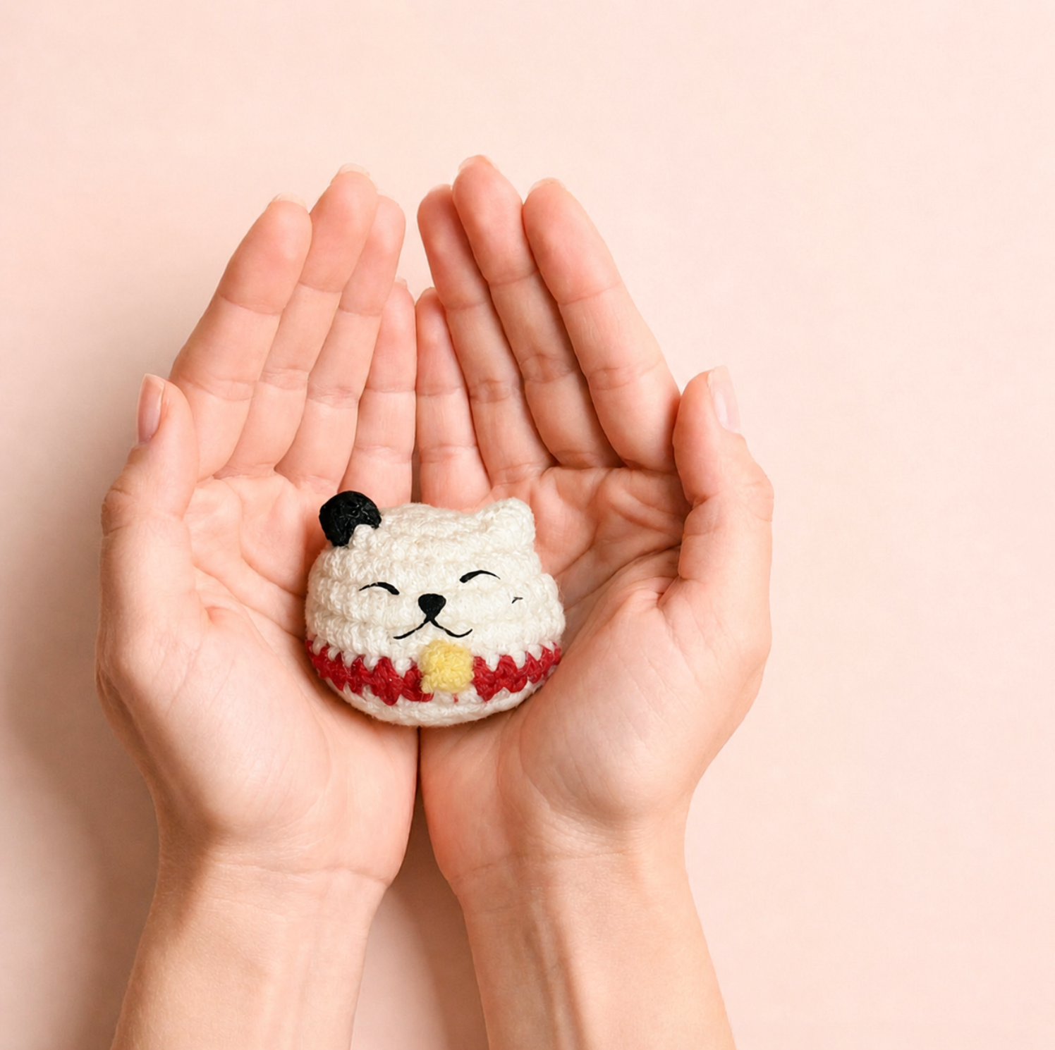 Small white woven lucky cat toy infused with Miracle Nip held in hands, soft plush texture and compact palm-sized scale
