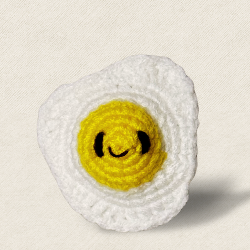 Close-up of Celeste the Fried Egg Chunkle and Puff cat toy, detailed woven texture with bright yellow center and soft white edges, luxury independent play cat toy for indoor cats with Miracle Nip by Feline Grove including silvervine and valerian