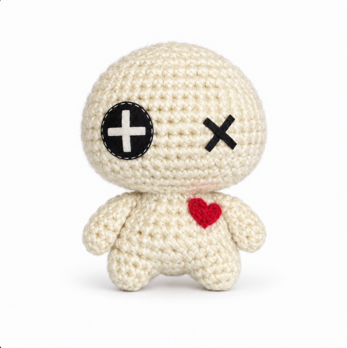 crocheted cat toy voodoo doll hero image showing a white handmade voodoo doll with a cartoonishly huge head and tiny body. The face has a button for its right eye and an X for its left eye and a heart applique on the body. The background is stark white.