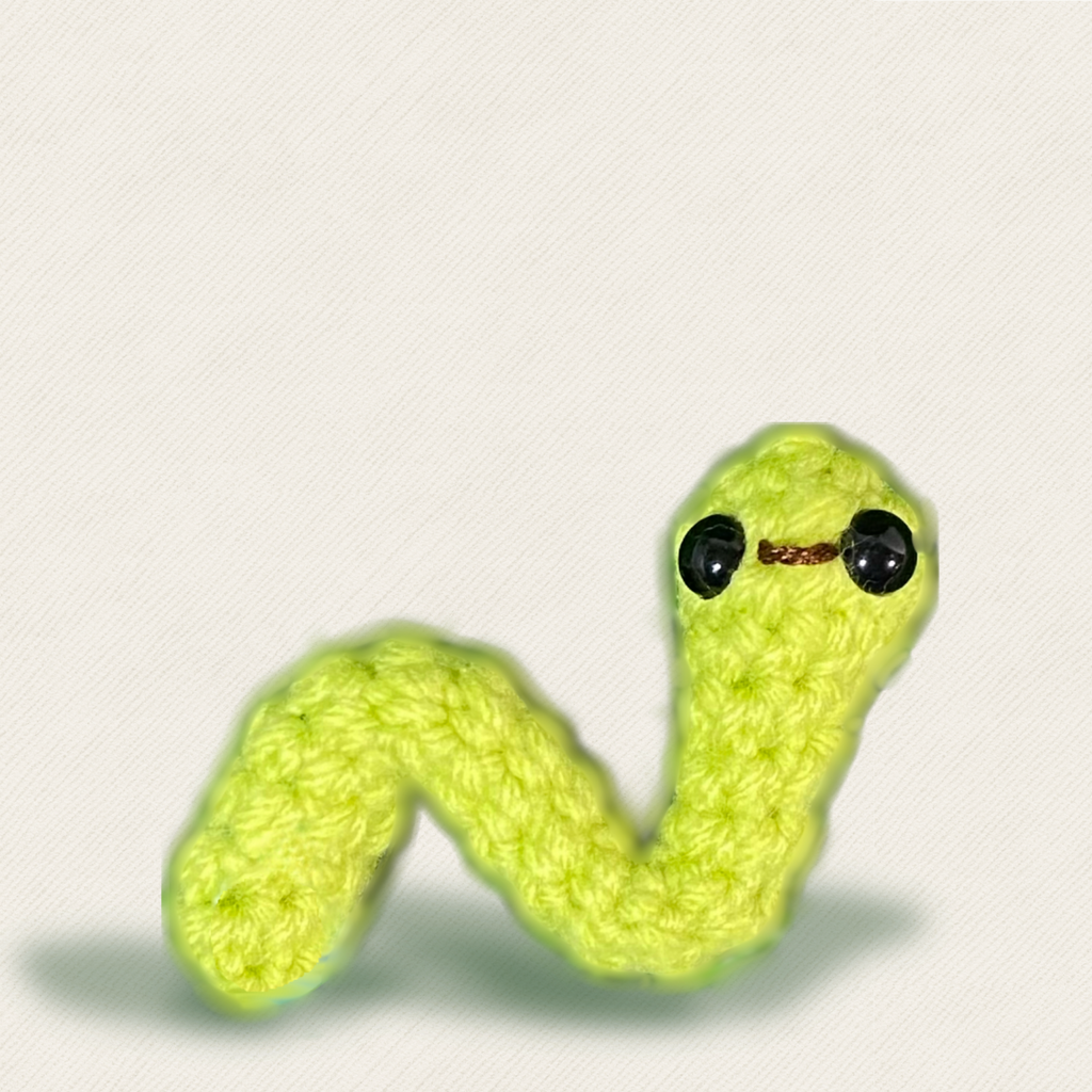 Close-up of woven green inchworm cat toy with glossy black eyes, soft textured yarn and curved body shape, compact lightweight design for batting and tossing, Chunkle & Puff toy infused with Miracle Nip